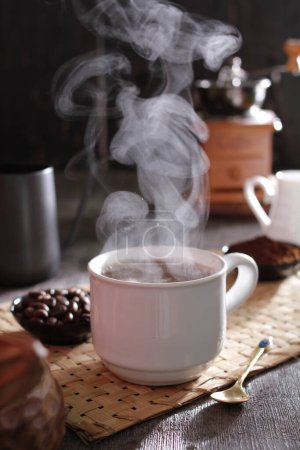 Foto de Taza de té caliente y una tetera sobre una mesa de madera - Imagen libre de derechos