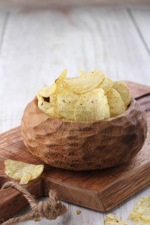 Photo for Bowl with tasty potato chips on wooden table - Royalty Free Image