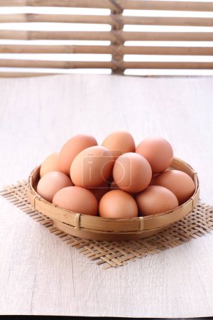Foto de Huevos en canasta sobre fondo de madera - Imagen libre de derechos