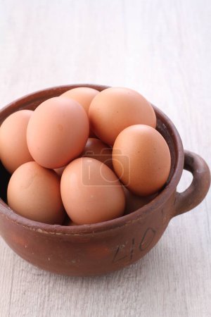 Foto de Un primer plano de los huevos en un tazón de barro aislado sobre un fondo blanco - Imagen libre de derechos