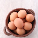 brown eggs in wooden bowl.