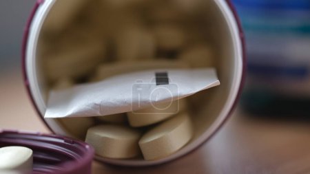 Foto de El desecante es un pequeño envase en un frasco de medicamento para un agente secante. Advertencia para no comer. - Imagen libre de derechos