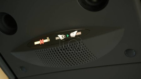 Foto de Señal de luz de cabina de no fumar y abrochar el cinturón de seguridad mientras el avión despega y aterriza. - Imagen libre de derechos