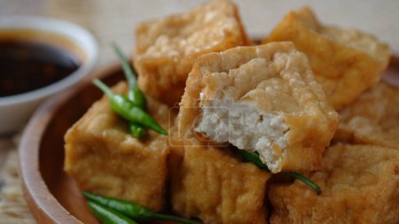 Photo for Fried milk tofu on a wooden plate. Tahu susu goreng. - Royalty Free Image
