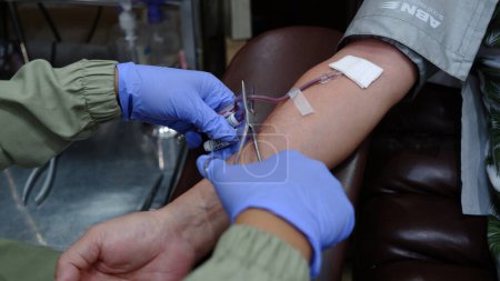 Téléchargez les photos : Les agents prélèvent le sang de patients qui font un don de sang pour des tests - en image libre de droit