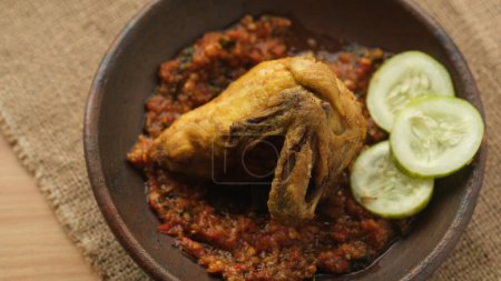 Téléchargez les photos : Poulet frit dans une assiette d'argile avec sambal. Alimentation indonésienne. - en image libre de droit