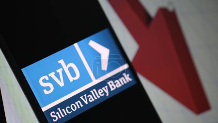 Foto de Logotipo SVB (Silicone Valley Bank) con un gráfico de flecha hacia abajo en el fondo. Yakarta 21 de marzo de 2023. - Imagen libre de derechos