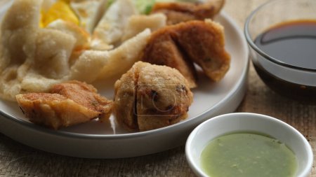 Photo for Mpek-Mpek Kapal Selam and Adaan with vinegar sauce and green chili in a cup. Mpek-Mpek is tradisional food from Palembang, Indonesia. - Royalty Free Image