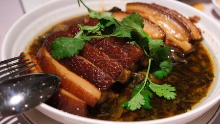 Téléchargez les photos : Porc Belly aux légumes à la moutarde confits et sauce soja foncée. Nourriture chinoise. - en image libre de droit