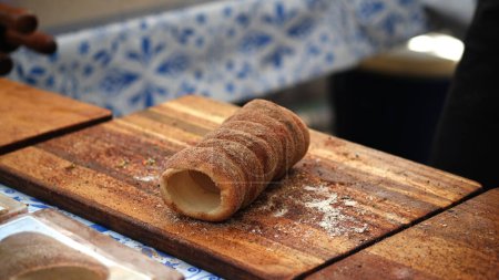 Photo for Kurtosh is made from yeast dough, of which a strip is spun and then wrapped around a truncated coneshaped baking spit, and rolled in granulated sugar. It is roasted over charcoal with melted butter, until its surface cooks to a golden-brown color. - Royalty Free Image