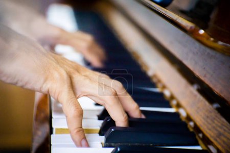 Foto de Close up male hand playing piano in the room. - Imagen libre de derechos