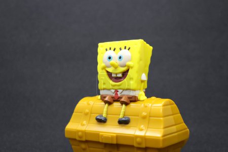 Photo for Sponge bob toy and treasure chest, with black background. - Royalty Free Image