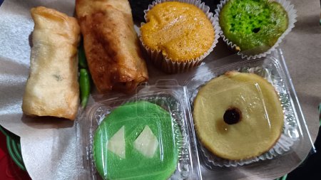 Various market snack cakes. There are chocolate cakes, mud cakes, risol and pandan cakes,