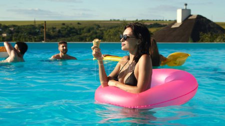 Photo for A group of beautiful young women are eating ice cream and having fun in the pool. - Royalty Free Image