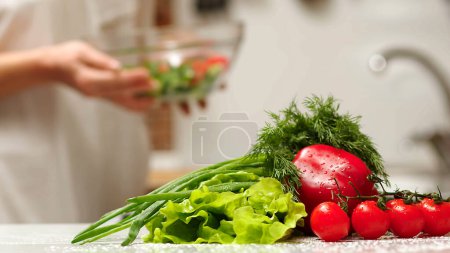 Photo for Making vegetable salad outdoors. Cooking salad from fresh raw vegetables - tomatoes, cucumbers, greens, pepper, scallion, onion, olive oil. Outdoors - Royalty Free Image