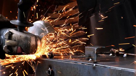 Photo for Factory worker welds metal. The man is welding. Welding with argon or electrode, using a welding machine. An industrial enterprise producing metal structures. Sparks and flashes fly. - Royalty Free Image