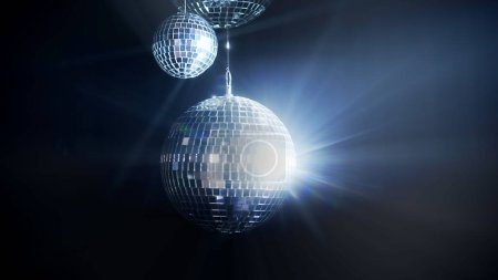 Photo for A colorful disco mirror balls illuminates the backdrop of a nightclub. The party lights up the disco ball. - Royalty Free Image