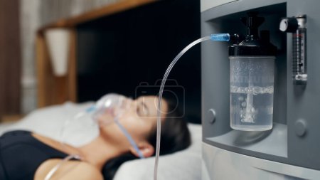 Photo for Portrait of a sick young woman who uses an oxygen concentrator and an inhaler for treatment at home. covid-19, bronchial asthma. Treatment, treatment and procedures, therapy. - Royalty Free Image