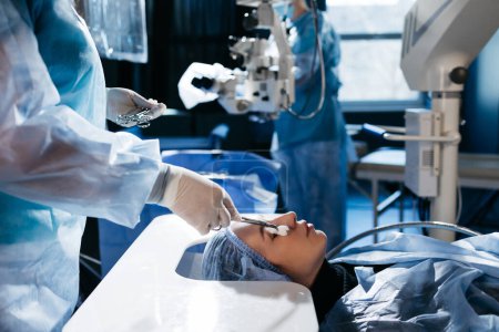 Photo for Hands of ophtalmology surgeons and assistants with ophtalmological surgery tools during surgical treatment. Eye disinfection. Doctor wears gloves - Royalty Free Image