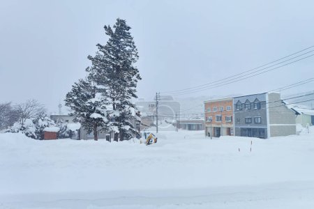 Téléchargez les photos : Snowplows are clearing roads for traffic during a winter snowstorm in Hokkaido - en image libre de droit