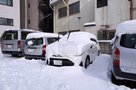 Foto de Hokkaido, Japan  - December 20, 2022 : Cars covered by thick snow on the side of the street in Hokkaido - Imagen libre de derechos