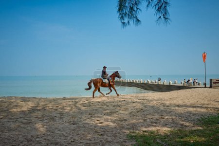 Téléchargez les photos : PENANG, MALAISIE - 29 sept. 2023 : Un touriste monte à cheval sur la plage Batu Ferringhi de Penang Island - en image libre de droit