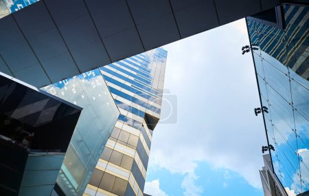 Photo for Modern glass exterior of business office building against sky from low angle view at Siam square in Bangkok, Thailand. - Royalty Free Image