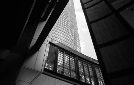 Foto de Vista monocromática de un imponente rascacielos visto a través de una estructura de vidrio y acero - Imagen libre de derechos