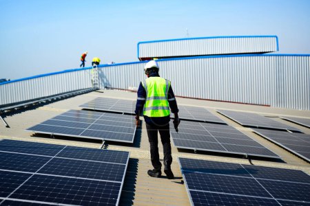 Foto de Professional engineer technician with safety helmet checking and operating system at solar cell farm power plant, Renewable energy source for electricity and power, Solar cell maintenance concept - Imagen libre de derechos