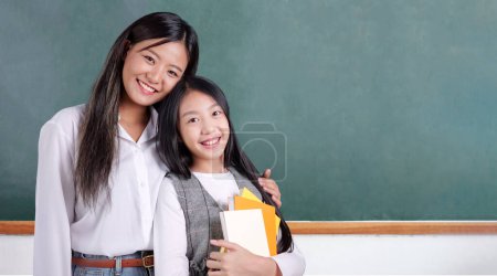 Cheerful schoolgirl in the classroom, Happy student studying with teacher in classroom at school, Learning development, Back to school concept