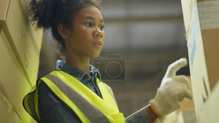 Photo for Industrial staff working in the factory warehouse, Hardworking female industrial worker using tablet to check stock in the store with sweat on head, Hard worker concept - Royalty Free Image