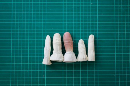 Photo for Parts of artificial silicone fingers prosthetic on workbench in prosthetic workshop, Worker assembling parts of artificial leg in prosthetic production workshop, New artificial limb production for - Royalty Free Image