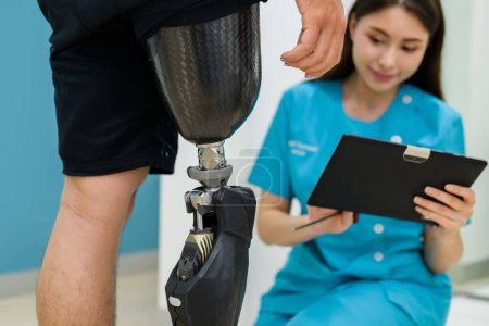 Photo for Young prosthetic technician holding prosthetic leg checking and controlling quality, Prosthetist nurse checking prosthetic leg of patient at health care, New artificial limb production for disabled - Royalty Free Image
