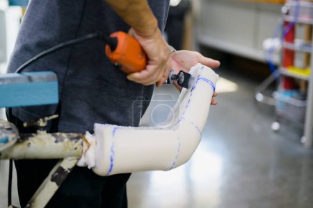 Téléchargez les photos : Travailleur prothétique faisant plâtre coulé pour douille à l'usine de production de prothèses, Spécialiste de l'ingénieur de développement avec la technologie de pointe à la fabrication de prothèses, Nouvelle production de membres artificiels - en image libre de droit