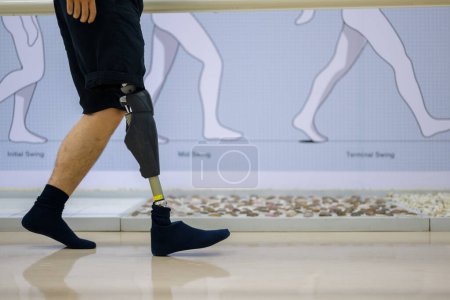 Téléchargez les photos : Athlète homme avec la jambe prothétique marche au centre de soins de santé, Les gens avec la technologie de pointe à la fabrication de prothèses, Nouvelle production de membres artificiels pour les personnes handicapées - en image libre de droit