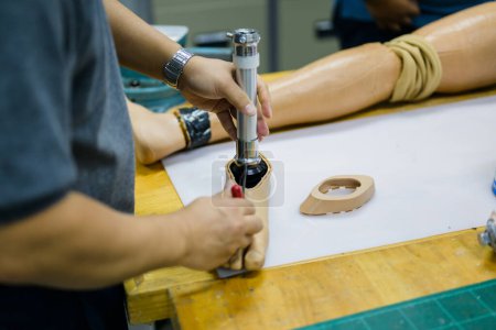 Photo for Male worker assembling parts of artificial leg in prosthetic production workshop, Development engineer with high tech technology at prosthetic manufacturing, New artificial limb production for - Royalty Free Image