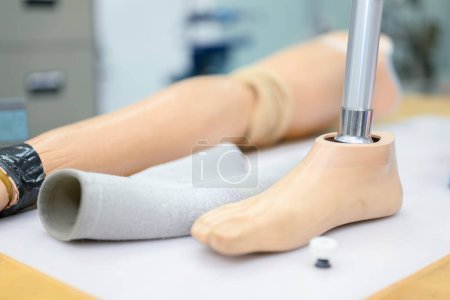 Photo for Parts of artificial leg and various tools on workbench in prosthetic workshop, Worker assembling parts of artificial leg in prosthetic production workshop, New artificial limb production - Royalty Free Image