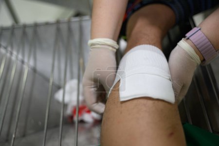Les infirmières soignent une blessure hémorragique à la jambe causée par un accident. Photo de haute qualité