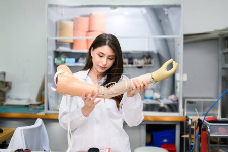 Photo for Female technician assembling and fixing parts of modern prosthetic arm, Prosthetic technician holding prosthetic device checking and controlling quality in laboratory, New artificial limb production - Royalty Free Image