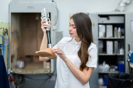 Photo for Young female technician holding prosthetic leg checking and working in laboratory, Specialist with high tech technology at prosthetic manufacturing, New artificial limb production for disabled people - Royalty Free Image
