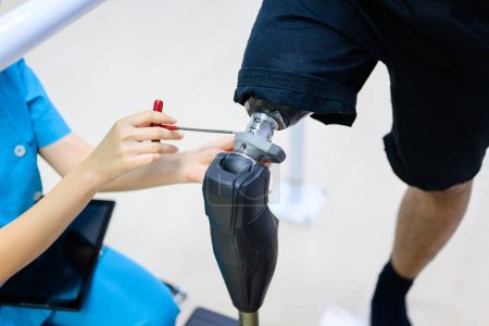 Photo for Physiotherapist adjusting prosthetic leg of patient in hospital, Disabled patient with treatment at health care center, New artificial limb production for disabled people - Royalty Free Image
