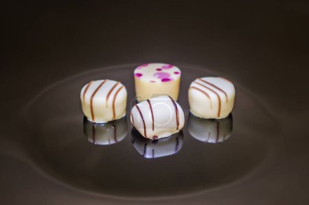 Téléchargez les photos : Quatre pralines au chocolat. Nombre de quatre truffes aux fraises, noix de coco, vanille et citron. - en image libre de droit