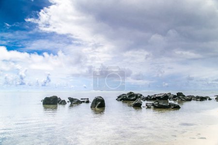 Tropische Bucht, paradiesische Destination auf den Cook Islands. Große Steine am Strand der tropischen Insel Rarotonga. Blaues Meer mit Felsen an einem sonnigen Tag. Kristallklares Wasser. Sommerreisekonzept.