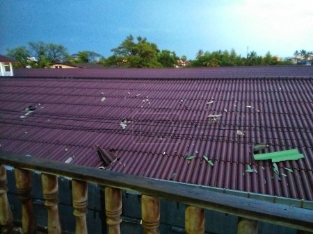 Photo for Roof damage with damaged roof tiles after earthquake in the city. - Royalty Free Image