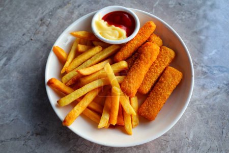 Photo for Fried fish sticks with French fries and ketchup and mayonnaise on white plate. - Royalty Free Image