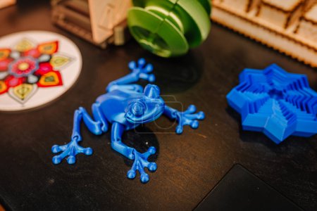 Foto de Máquina automática de impresión 3D modelo de plástico de juguete de rana azul en la exposición de tecnología moderna. Impresión 3D, tecnologías aditivas, 4.0 revolución industrial y concepto futurista - Imagen libre de derechos