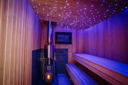 Photo for Modern sauna design with led lights and sauna stove. - Royalty Free Image