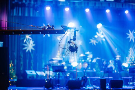 Foto de Valmiera, Letonia - 28 de diciembre de 2023 - escenario con una cámara en una grúa, instrumentos musicales y decoraciones estelares, todo bajo iluminación de escenario azul - Imagen libre de derechos