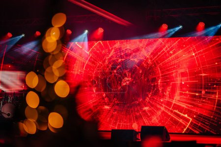 stage with an intense red light display resembling a digital tunnel and blurred lights in the foreground