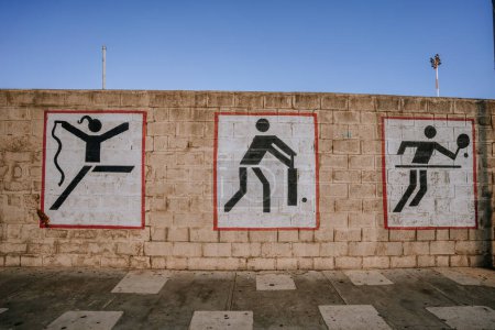 Foto de Gibraltar, Gran Bretaña - 24 de enero de 2024 - tres pictogramas deportivos pintados en una pared que representa karate, fútbol y tenis de mesa. - Imagen libre de derechos